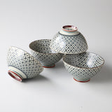 Set of four ceramic bowls with geometric patterns on a white background