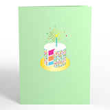 Pale green birthday card cover with a colorful cake illustration