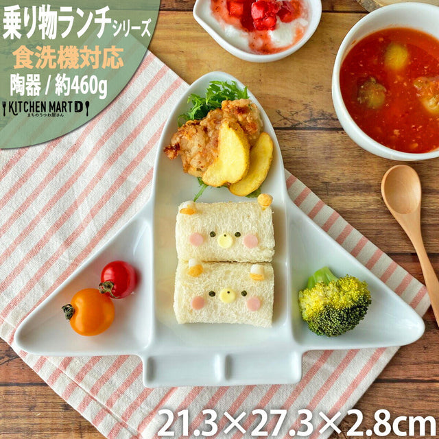 Children's lunch set with sandwich, vegetables, and soup on a wooden table.